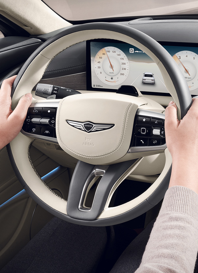 The Genesis steering wheel appears enlarged.